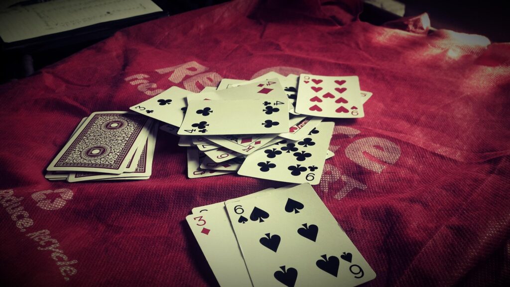 A deck of cards piled on a red surface