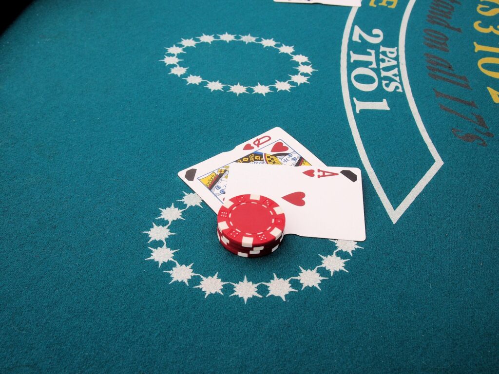 A blackjack on a card table with chips stacked on top of it